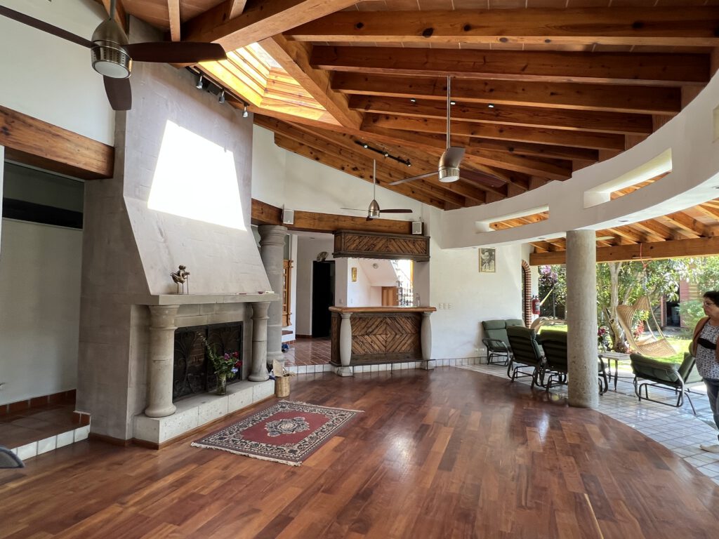 The common room, with a beamed wooden ceiling and a stone fireplace