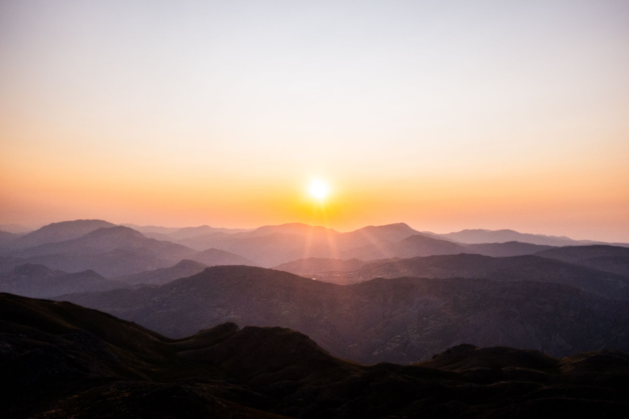 Golden sunrise over layered mountains