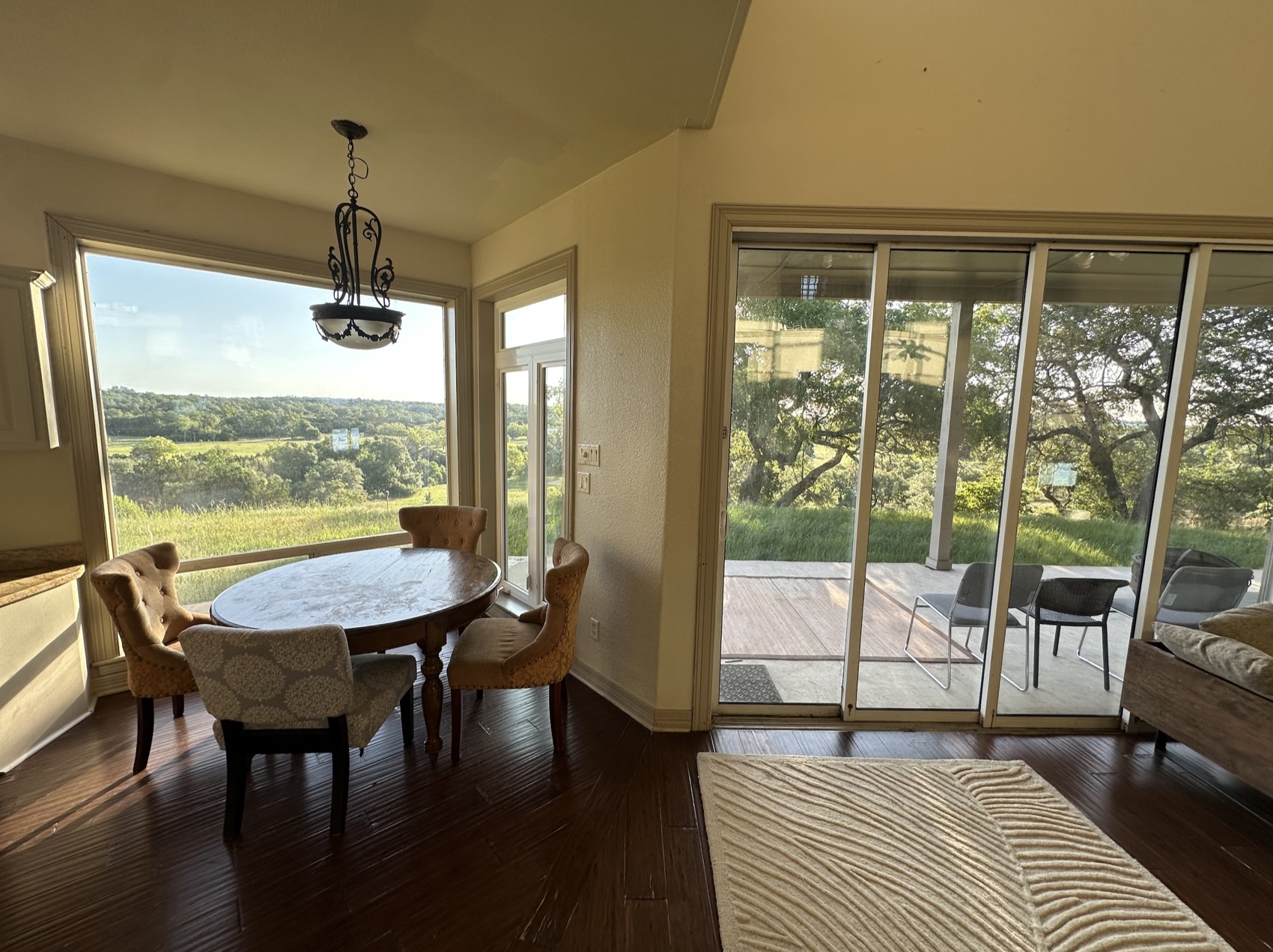 A light-filled dining nook with a round table and wide windows onto the land